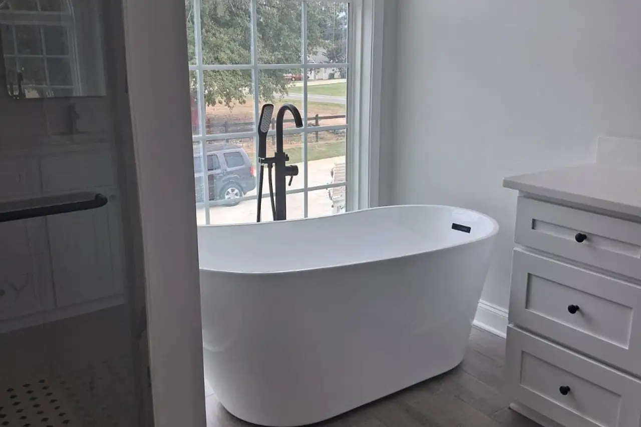 Baño terminado con tina libre junto a una ventana en arco