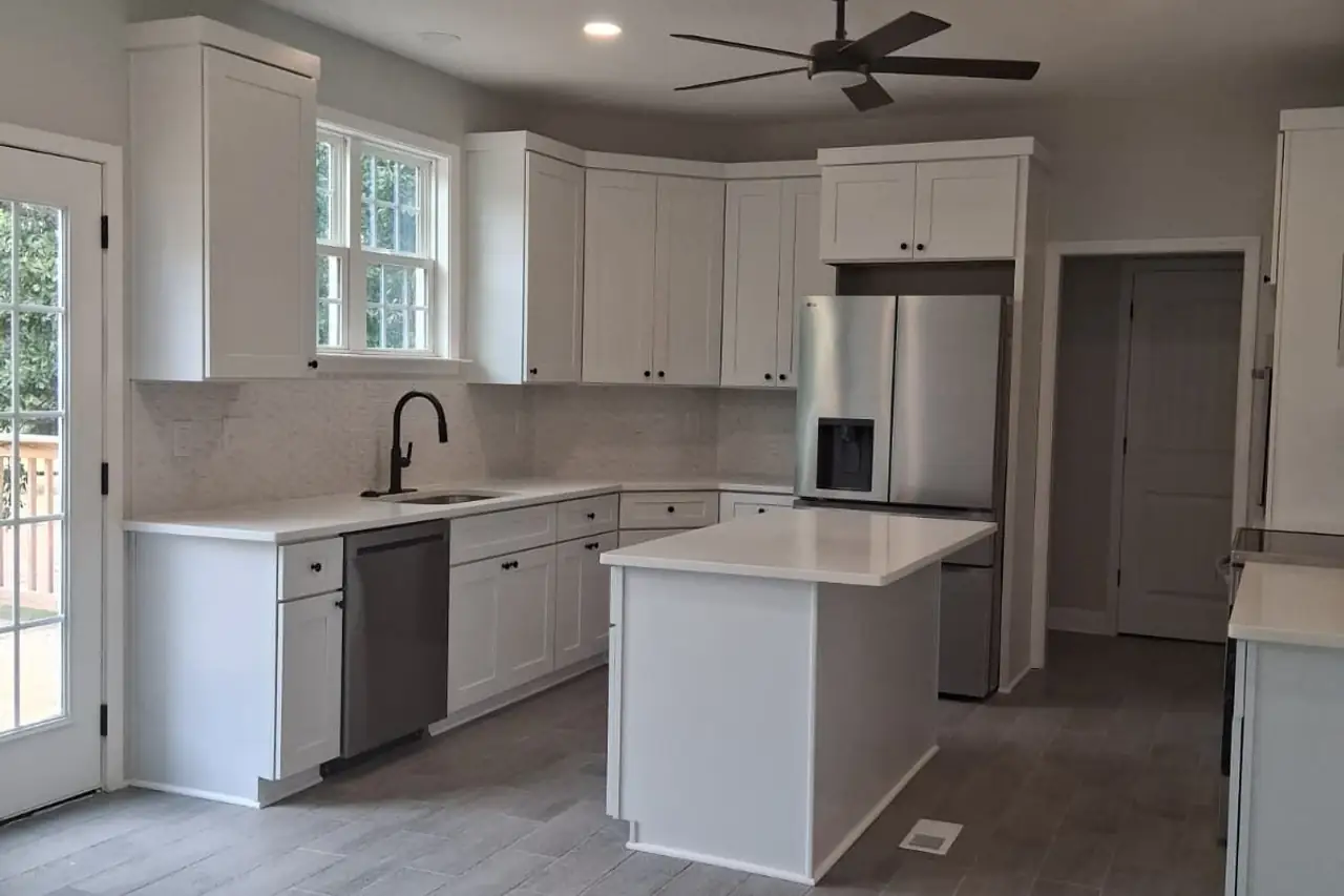 Cocina terminada con gabinetes blancos, isla y piso nuevo