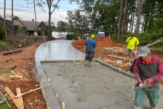 Cuadrilla de VO Remodeling LLC colando y alisando una entrada de concreto