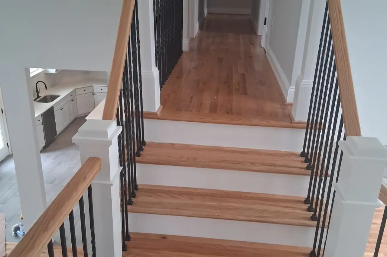 Escalera con escalones de madera, barandal y balaustres negros